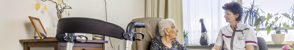 verzorgende-bij-oudere-vrouw-in-kamer-verzorgingshuis-header