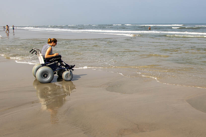Vrouw in rolstoel aan het strand