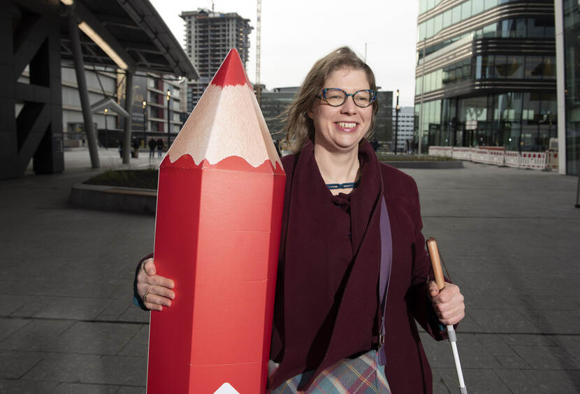 Slechtziende vrouw met blindenstok en groot rood stempotlood voor het Stadskantoor Utrecht