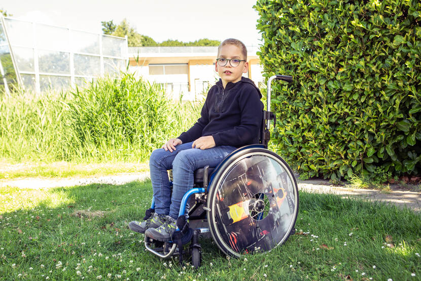 Een kind in een rolstoel op een grasveld